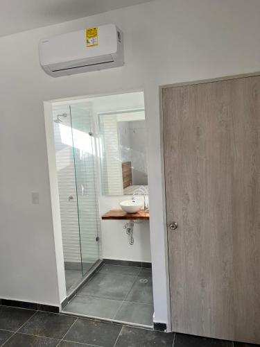 a bathroom with a glass shower and a sink at Comunidad Calle 13 Hotel Boutique in Santa Marta