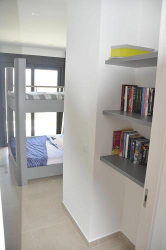 a bedroom with a bunk bed and a book shelf at Casa del Mar Menor in San Javier