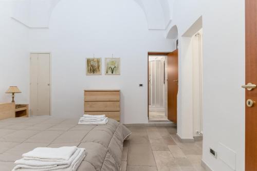 a white room with a bed and a mirror at White House Flats & Studios in Ostuni
