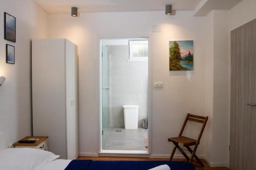 a bedroom with a glass door leading to a shower at Old stone house in historical area in Split