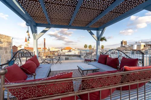 a patio with couches and tables on a roof at Arabesque Arts & Residency in ‘Akko