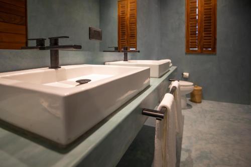 a white bathroom with two sinks and a toilet at Turquoise Tulum Hotel in Tulum