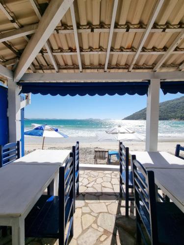 a view of the beach from a restaurant with tables and chairs at Pousada Seven in Arraial do Cabo