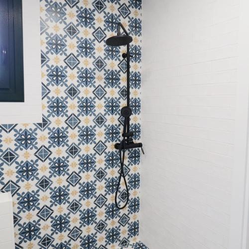 a shower in a bathroom with blue and white tiles at Casa Leonor de Aurora in Zas