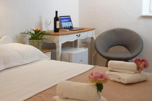 a bedroom with a bed and a desk with a laptop at Old stone house in historical area in Split
