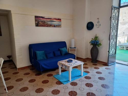 a living room with a blue couch and a table at Il Ponte in Naples