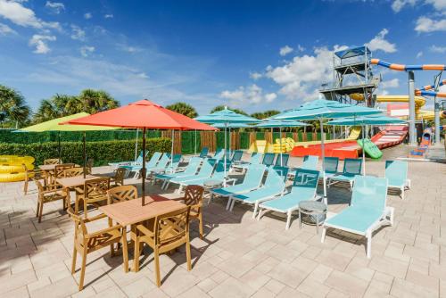 
a patio area with tables, chairs and umbrellas at Coco Key Hotel & Water Park Resort in Orlando
