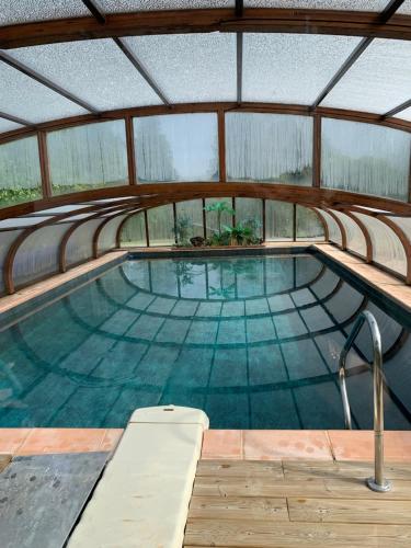 une piscine intérieure avec toit dans l'établissement LA MAISON DE FAMILLE, à Néville