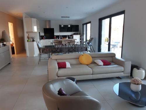 un salon avec un canapé et une table dans l'établissement La grande Maison, à Donzenac