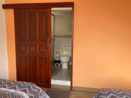 a door leading to a bathroom with a toilet at Panchi´s House in Baños