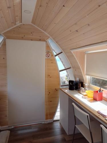 a kitchen in a tiny house with a large window at Cabañas Playa Linda in Pucón