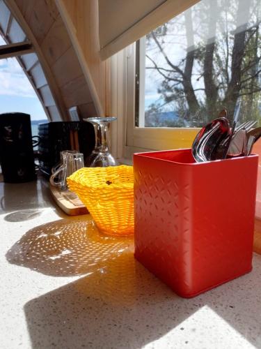 a red container sitting on a counter with a basket at Cabañas Playa Linda in Pucón
