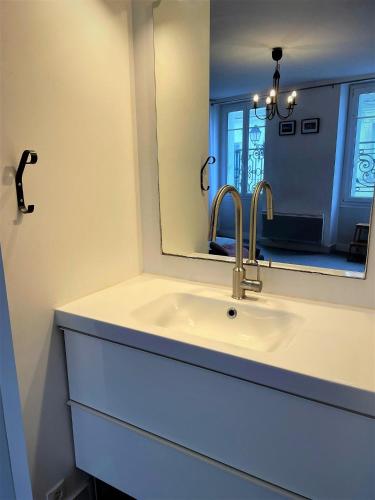 une salle de bain avec un lavabo et un miroir dans l'établissement Gîte de Ponpon, à proximité du Zoo et des Châteaux de la Loire, à Selles-sur-Cher