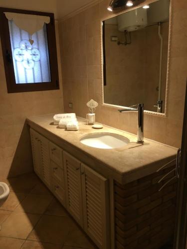 a bathroom with a sink and a mirror at Domu de Bisu in Villasimius
