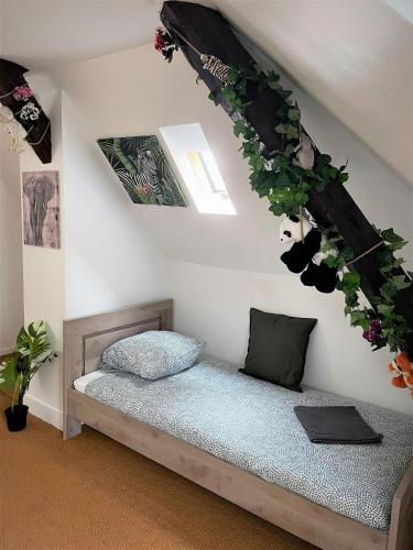 - une chambre dotée d'un lit avec des plantes sur le mur dans l'établissement Gîte de Ponpon, à proximité du Zoo et des Châteaux de la Loire, à Selles-sur-Cher