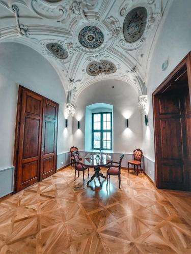 a room with a table and chairs and a ceiling at Zámek Třešť in Třešť