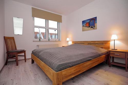 ボルテンハーゲンにあるSünnslag Wohnung 066のベッドルーム1室(ベッド1台、デスク、椅子付)