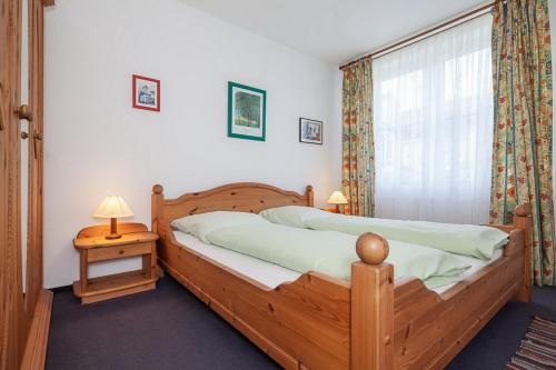 a bedroom with a wooden bed and a window at Sünnslag Wohnung 079 in Boltenhagen