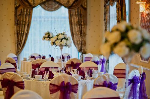 a room filled with tables and chairs with purple bows at Royal Park Hotel & Spa in Mielno
