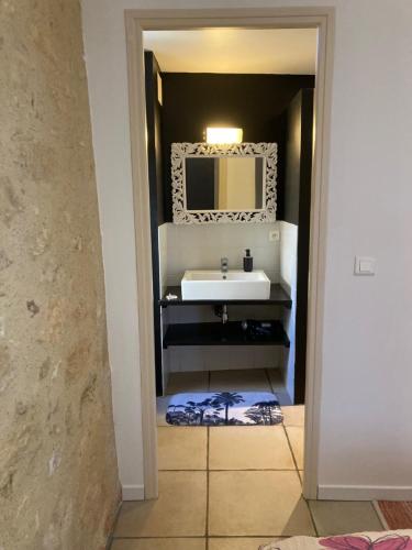 un bagno con lavandino e specchio di Les Roses a Barjou