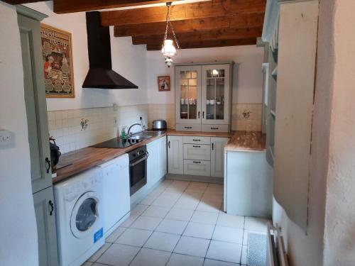 a kitchen with white appliances and a washer and dryer at Cheerful Cottage in Westport
