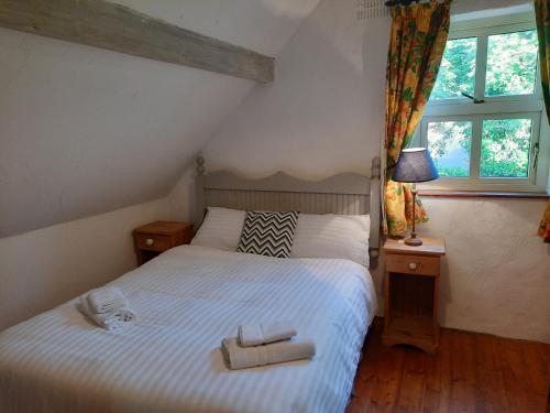 a bedroom with a bed with two towels on it at Cheerful Cottage in Westport