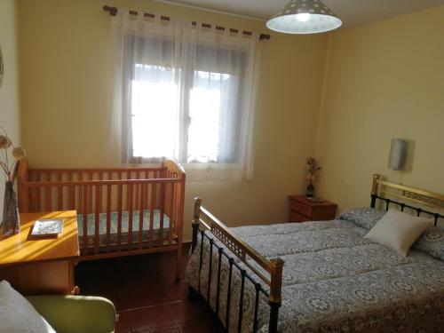 Alojamientos Lunada في كانديليدا: غرفة نوم بسريرين وطاولة ونافذة