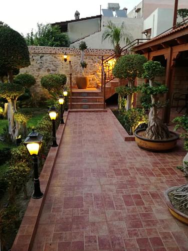 a courtyard with lights and bonsai trees at Paris Hotel in Rhodes Town