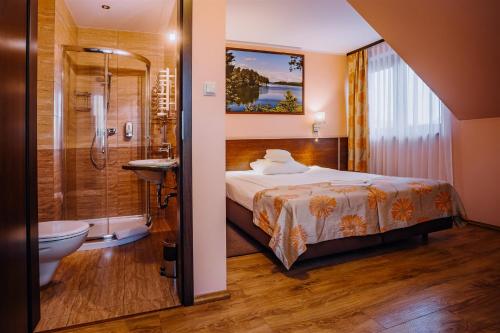 アウグストゥフにあるVilla Skomandaのベッドルーム1室(ベッド1台、シャワー、トイレ付)