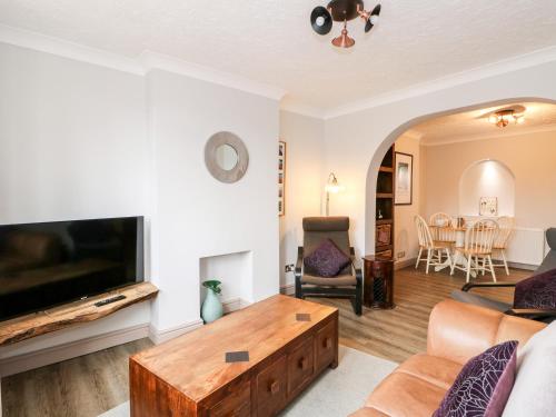 a living room with a tv and a couch and a table at 57 Southend Road in Hunstanton