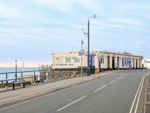 an empty street with a building next to the ocean at 57 Southend Road in Hunstanton
