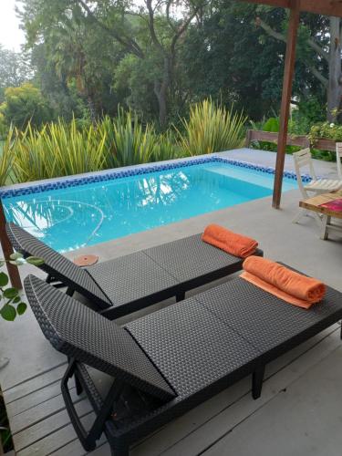 a table and chairs next to a swimming pool at Rouana Guest Farm in Stellenbosch