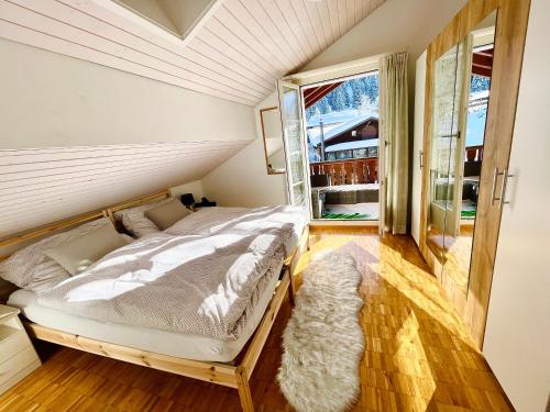 um quarto com uma cama e uma grande janela em The Swiss Paradise 1 Penthouse apartment em Wirzweli