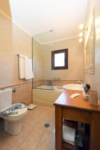 a bathroom with a toilet and a tub and a sink at Paris Hotel in Rhodes Town