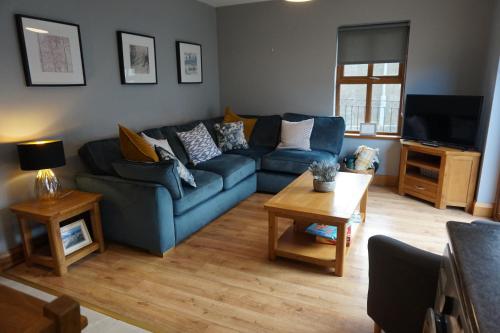 a living room with a blue couch and a table at Dromore Court in Warrenpoint