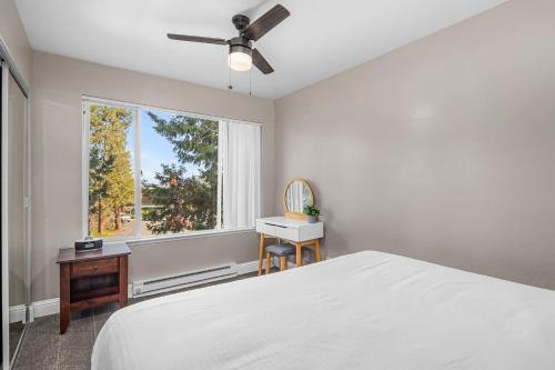 a white bedroom with a bed and a window at The Inn at Boatworks, Lake Tahoe in Tahoe City