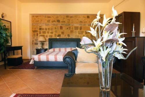 a vase of flowers on a table in a bedroom at Paris Hotel in Rhodes Town