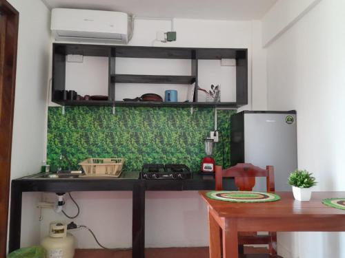 a kitchen with a stove and a table and a refrigerator at Hotel Doña Mary Huatulco in Santa Cruz Huatulco