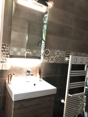 une salle de bain avec un lavabo et un miroir dans l'établissement Studio 2 pers avec vue sur l'océan, à Lacanau