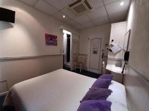 a small room with a bed and a desk at Hotel Mignon in Avignon