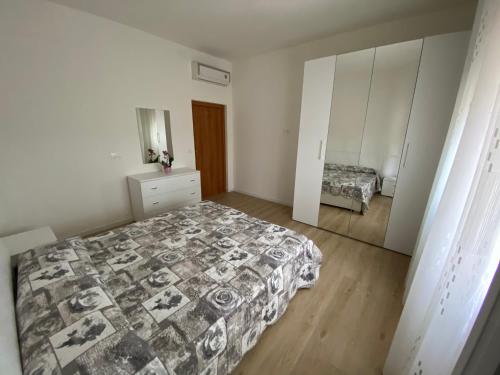 a bedroom with a bed and a dresser and a mirror at Cygnus Bed & Breakfast in Lido di Jesolo