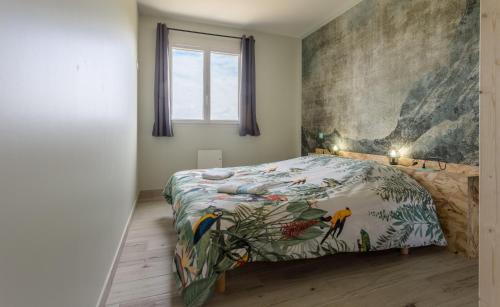 - une chambre avec un lit orné d'une peinture murale dans l'établissement Tribord, appt avec terrasse et vue mer, parking, à Saint-Côme-de-Fresné