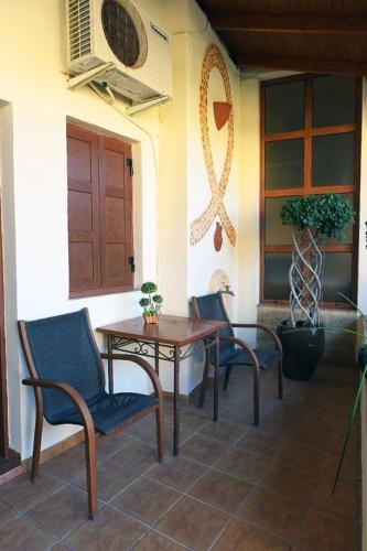 a patio with two chairs and a table and a door at Paris Hotel in Rhodes Town