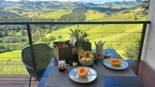 a table with plates of fruit on a balcony at Pousada Casa Bambu in Cunha