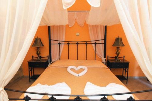a bedroom with a bed with a heart on it at Paris Hotel in Rhodes Town