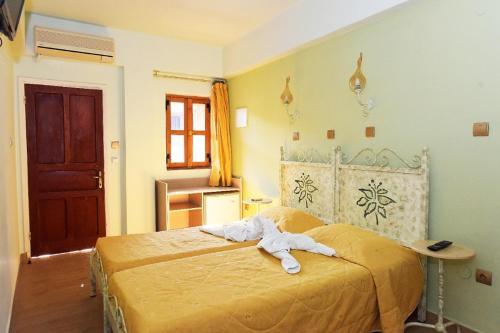 a bedroom with a bed with a towel on it at Paris Hotel in Rhodes Town