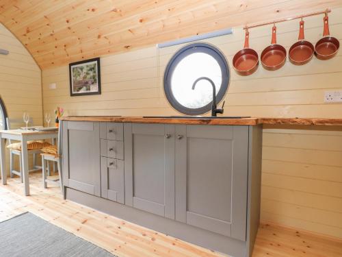 a kitchen with a counter with pots and pans on the wall at Filbert Pod in Arundel
