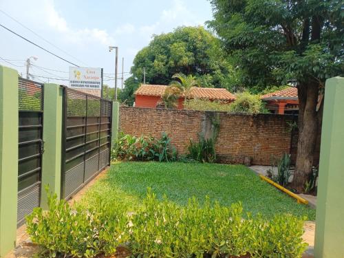 a fence in front of a yard withgrass at Casa Naranja in San Lorenzo