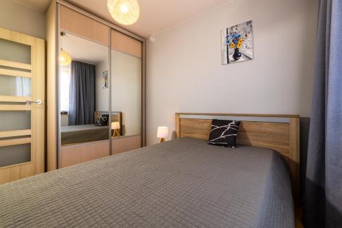 sypialnia z łóżkiem i lustrem w obiekcie Apartament Atlantycki w Jastrzębiej Górze