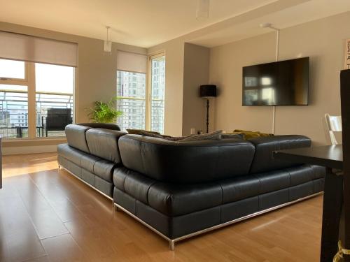a black leather couch in a living room at The Cardiff Apartment in Cardiff